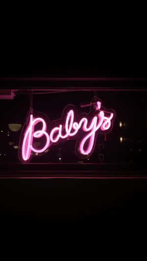 在黑暗的城市環境中，寫著 Baby's 的粉紅色霓虹燈牌。 — 鎖定螢幕 壁紙