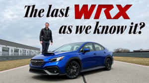 男子站在賽道上藍色 Subaru WRX 的引擎蓋上。