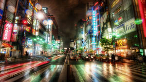 雨濕的東京街道在夜晚閃爍著霓虹招牌和模糊的車燈。