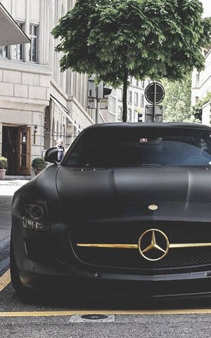 啞光黑色梅賽德斯 SLS AMG 停放在城市街道上，綠樹成蔭。