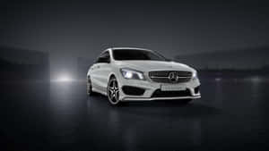 白色Mercedes CLA-Class轎車在夜間霧氣瀰漫潮濕的道路上被照亮。
