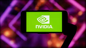 手拿著手機，顯示NVIDIA標誌，背後有霓虹燈。