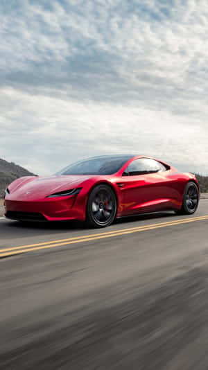 紅色Tesla Roadster在山路上飛馳，帶有動態模糊效果。
