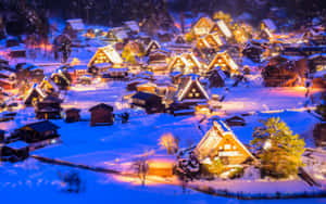被雪覆蓋的日本村莊房屋在夜間溫暖地亮起。