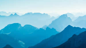 寧靜的山景，層層疊疊的山峰逐漸消失在藍色霧氣中。