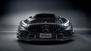 黑色 Mercedes-AMG GT S 跑車，配備發光頭燈，在黑暗的攝影棚中。