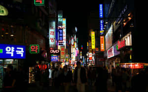 韓國夜晚的街道，充滿發光招牌和行人。 — 韓國 壁紙