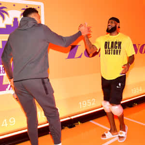 兩名籃球運動員在湖人隊主題球場上擊掌，身穿「Black History」球衣。 — 籃球 壁紙