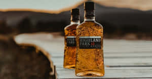 日落時分，木碼頭上的兩瓶 Highland Park 威士忌。