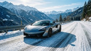 銀色跑車在白雪皚皚的山路上，有積雪的山峰和常青樹。