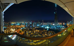 從弧形玻璃陽台觀賞杜拜天際線的夜景，哈利法塔燈火通明。