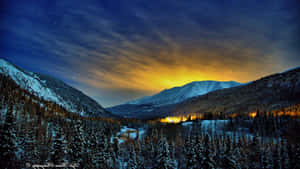 夜晚白雪覆蓋的山脈，星空和金色山谷。