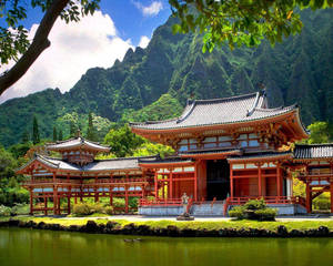 池塘旁的紅色木造寺廟，背景有翠綠山巒 — 廟宇 壁紙
