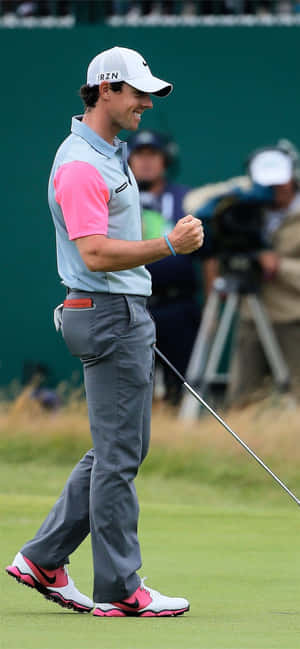 高爾夫球手Rory McIlroy在綠色高爾夫球場上慶祝成功的一擊。
