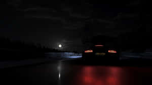 一輛紅色發光的跑車在滿月下夜間行駛在雪路上。 — 極限競速：地平線4 壁紙