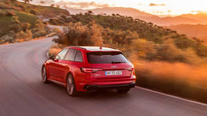 紅色Audi RS4 Avant在日落時分在蜿蜒的山路上疾馳。 — 奧迪 GIF 壁紙