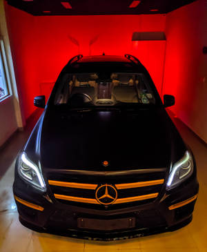 黑色梅賽德斯-奔馳SUV在紅色照明的展廳中，車頭燈閃爍。 — Galaxy Z Fold 5 壁紙