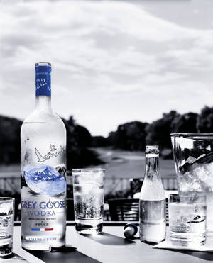 Grey Goose 伏特加酒瓶和加冰的酒杯放在戶外的桌子上。