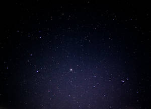 一個繁星點點的夜空，遠處有一個明亮的星體在發光。