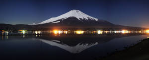 富士山在夜間湖中倒映，村莊燈光與星星