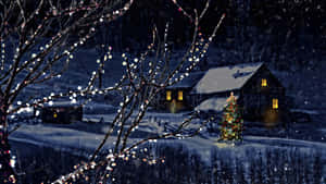 積雪的小屋，發光的窗戶，以及冬夜中點亮的聖誕樹。 — 聖誕節桌面 壁紙