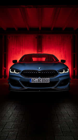 藍色BMW汽車在昏暗車庫中被紅燈照亮。