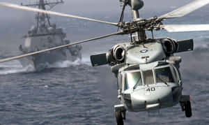 軍用直升機在海洋上空飛行，附近有軍艦。