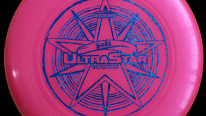 粉紅色Discraft UltraStar飛盤，帶藍色星星設計