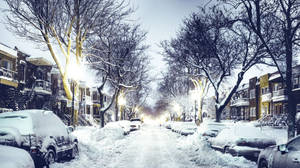 夜晚被雪覆蓋的城市街道，發光的街燈和停放的汽車。