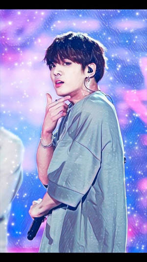 K-pop 表演者在星光下舞台上握著麥克風。