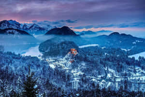 雪覆蓋的山湖，黃昏時分有發光的城堡。