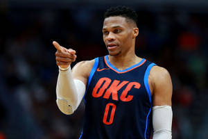身穿OKC球衣的籃球運動員在比賽中指。