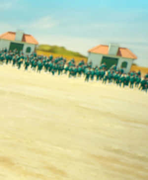在沙地上兩座小建築物之間排成隊形的模糊軍事人員。