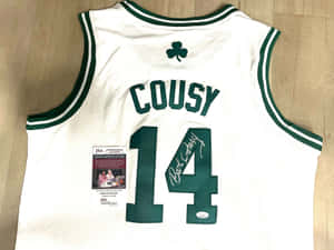 Bob Cousy簽名塞爾特人球衣，附JSA認證，置於木地板上。 — 白色 壁紙