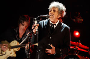 Bob Dylan 在紅色燈光下與結他手在舞台上現場演唱。 — 黑白 壁紙