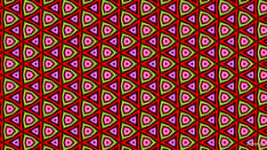 紅色、粉紅色和綠色三角形重複設計的大膽幾何圖案。 — 2560x1440 壁紙