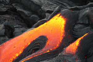 熔岩流過深色火山岩，帶有發光的橙色和紅色色調。 — MacBook Pro 14 壁紙