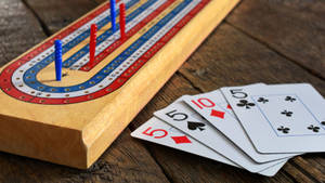 克里比奇棋盤、棋釘和撲克牌放在木質表面上。