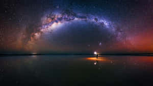 一個人獨自站在反射的鹽灘上，在充滿活力的星空下，有銀河。 — 太空 壁紙