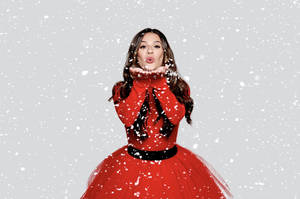 冬季場景中穿紅裙的女性吹雪花 — 可愛聖誕風格 壁紙