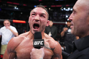 UFC拳手在血腥比賽後於八角籠內慶祝勝利。