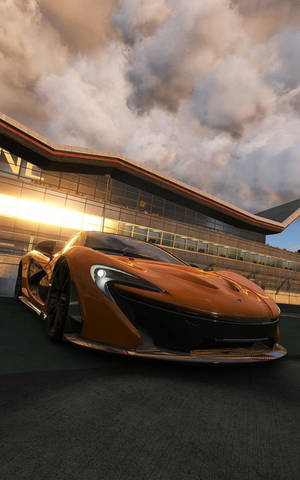 橙色McLaren跑車在日落時停泊在賽道上。