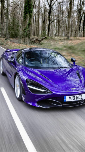 紫色McLaren跑車在樹林道路上疾馳。