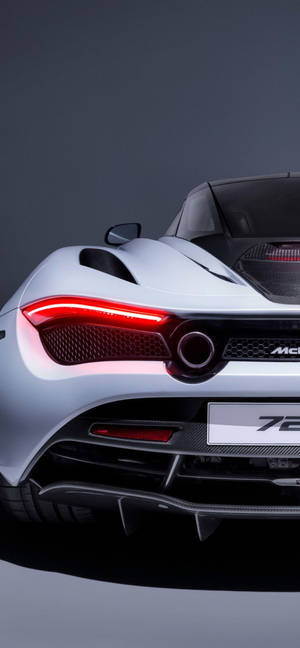 銀色McLaren 720S跑車後視圖，帶有紅色尾燈，在工作室中。