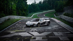 銀色McLaren P1在蜿蜒的賽道上，兩旁是樹木繁茂的山丘。 — 4K 法拉利 壁紙