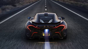 黃昏時分，黑色McLaren跑車在沙漠公路上飛馳。