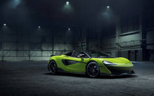 在黑暗工業倉庫中，聚光燈下的青檸綠色McLaren跑車。