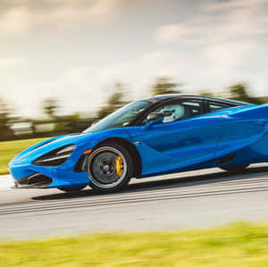 一輛藍色McLaren 720S在道路上疾馳，背景模糊。