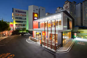 夜晚的麥當勞餐廳，設有得來速車道和閃爍的窗戶。