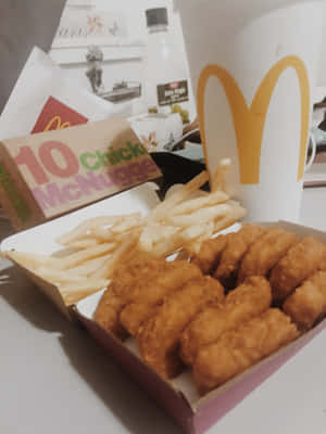 麥當勞麥樂雞和薯條，桌上有一個飲料杯。 — 雞丁 GIF 壁紙